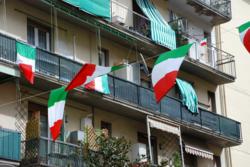 Picture of an apartment building in Italy with flags out for March 17th